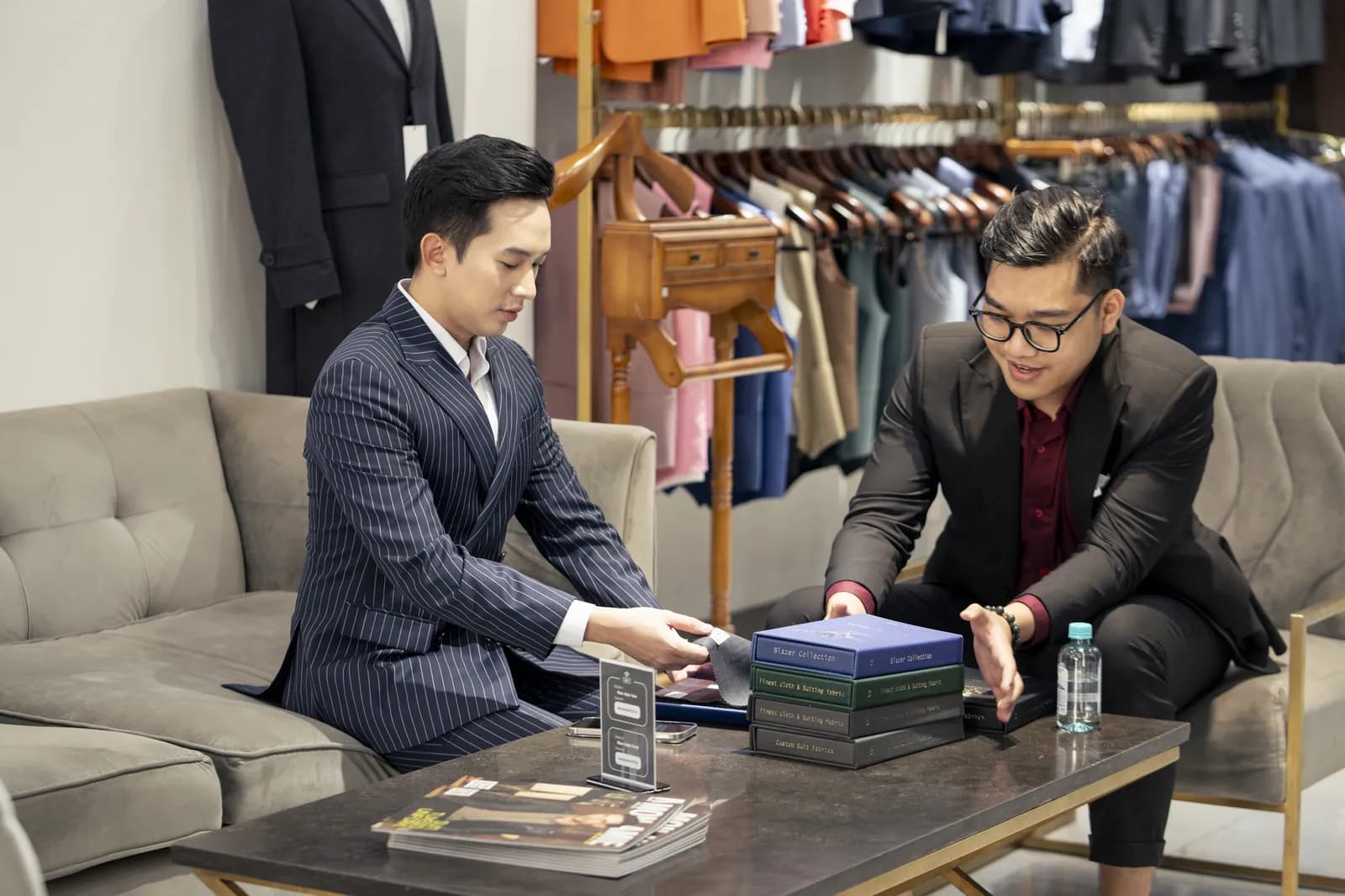 MC Trung Hậu cùng chuyên viên Mon Amie xem sổ mẫu vải tại showroom