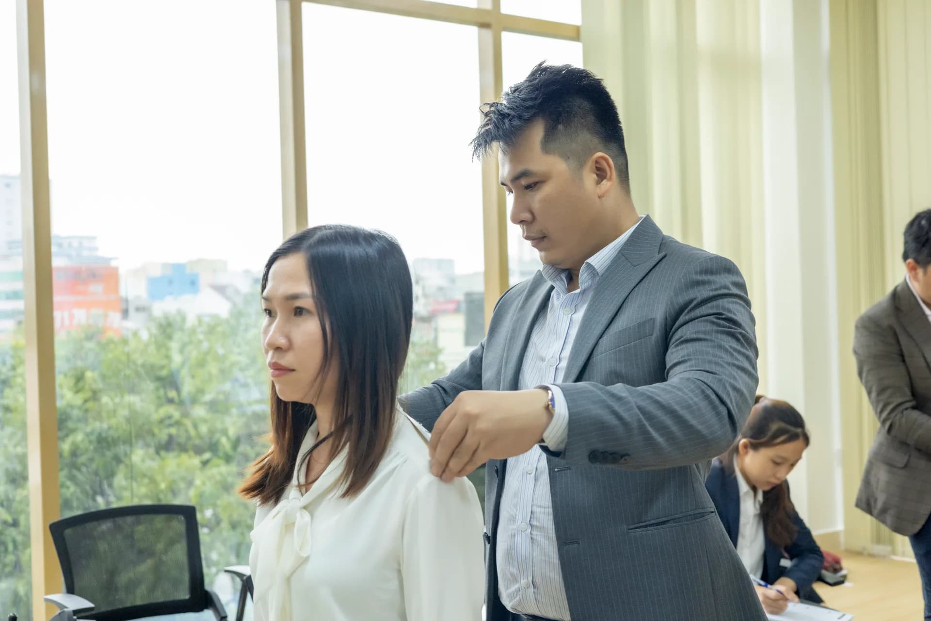 Đo vai cho nhân viên nữ tại văn phòng công ty