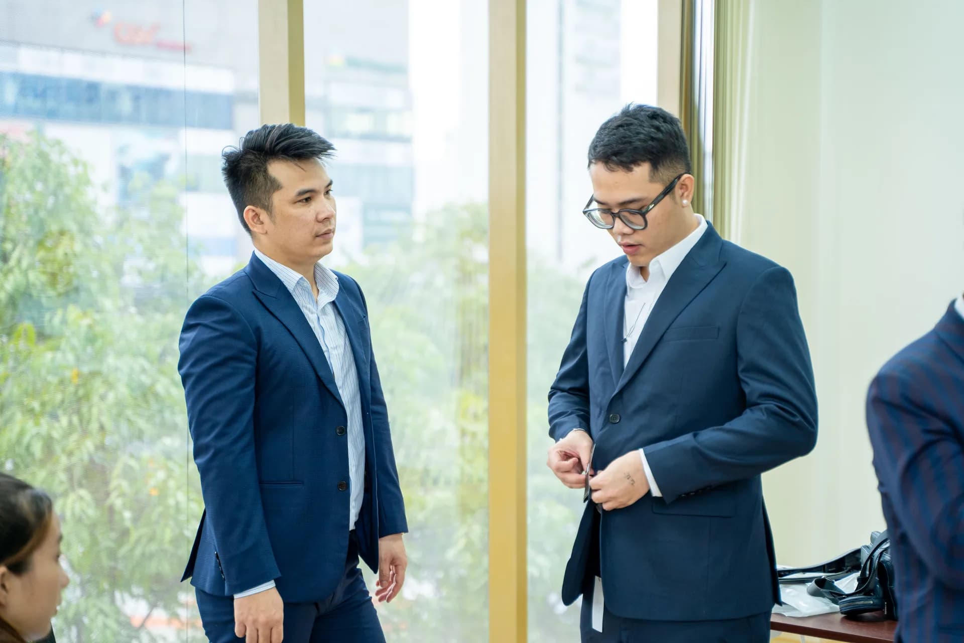 Nhân viên nam thử vest xanh navy, đối chiếu form sau khi nhận đồng phục