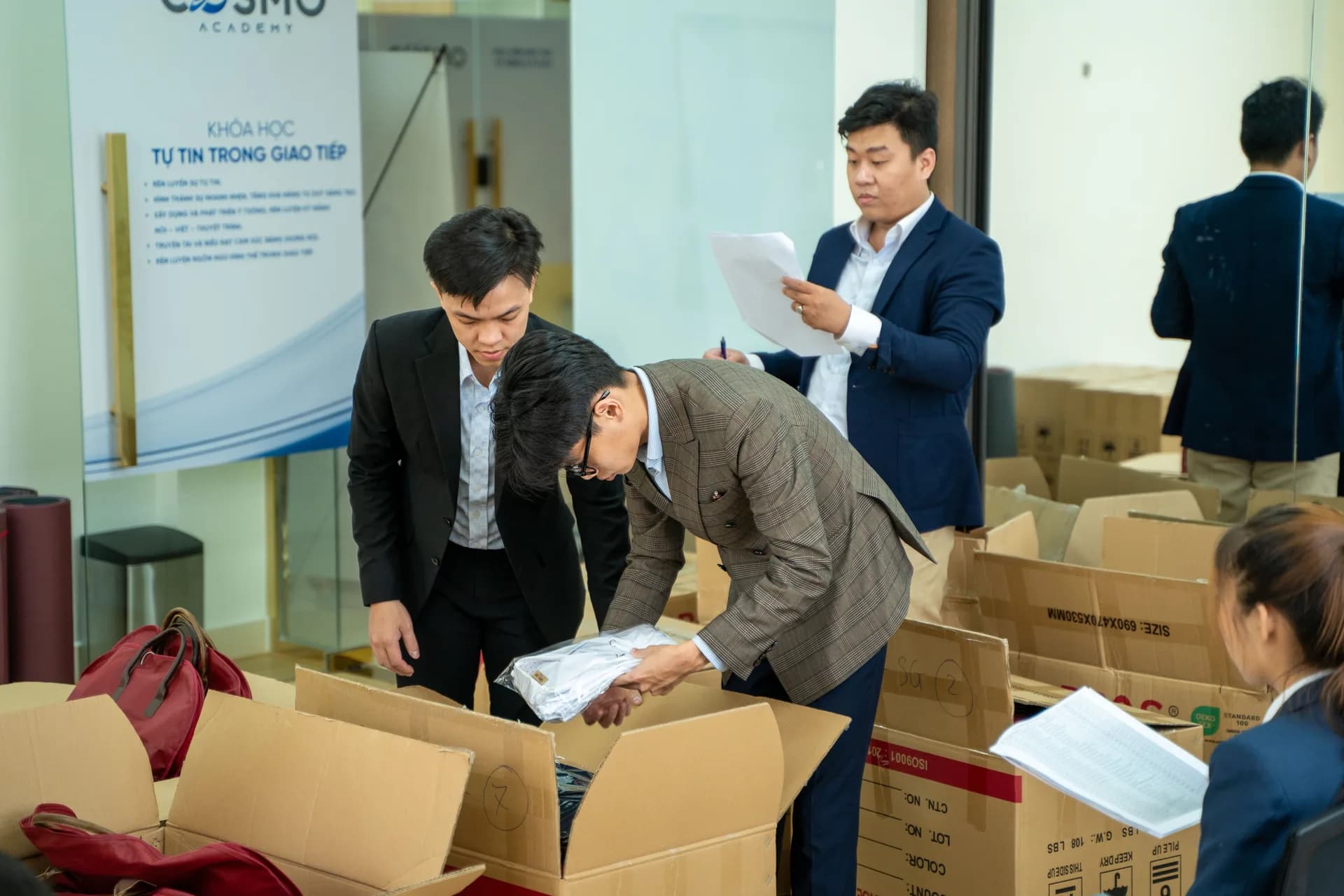 Lấy đồng phục từ thùng, kiểm tra từng bộ theo danh sách trước khi giao