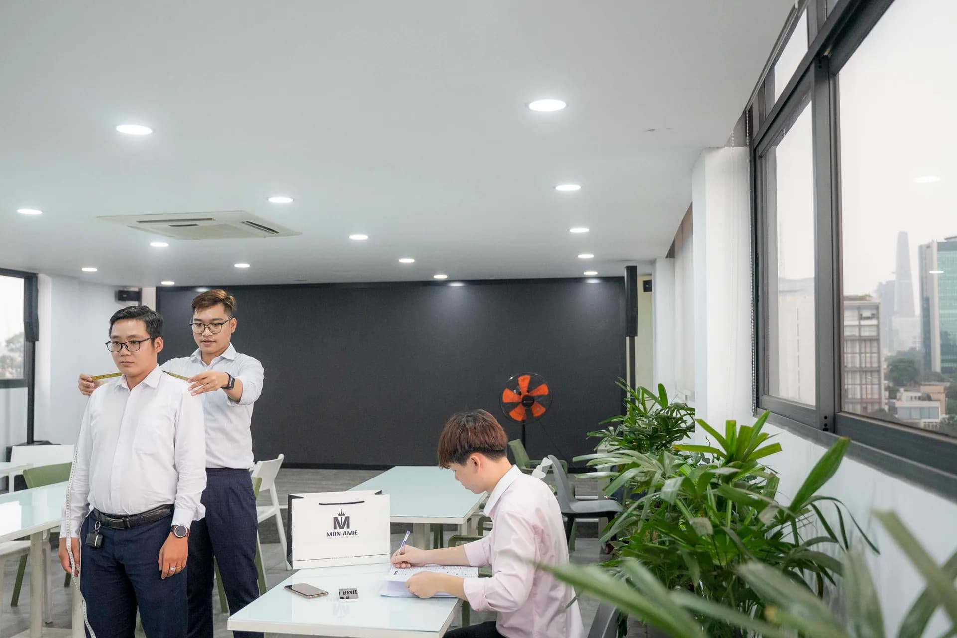 Đo vai cho nhân viên nam ERAS Group giữa phòng họp sáng