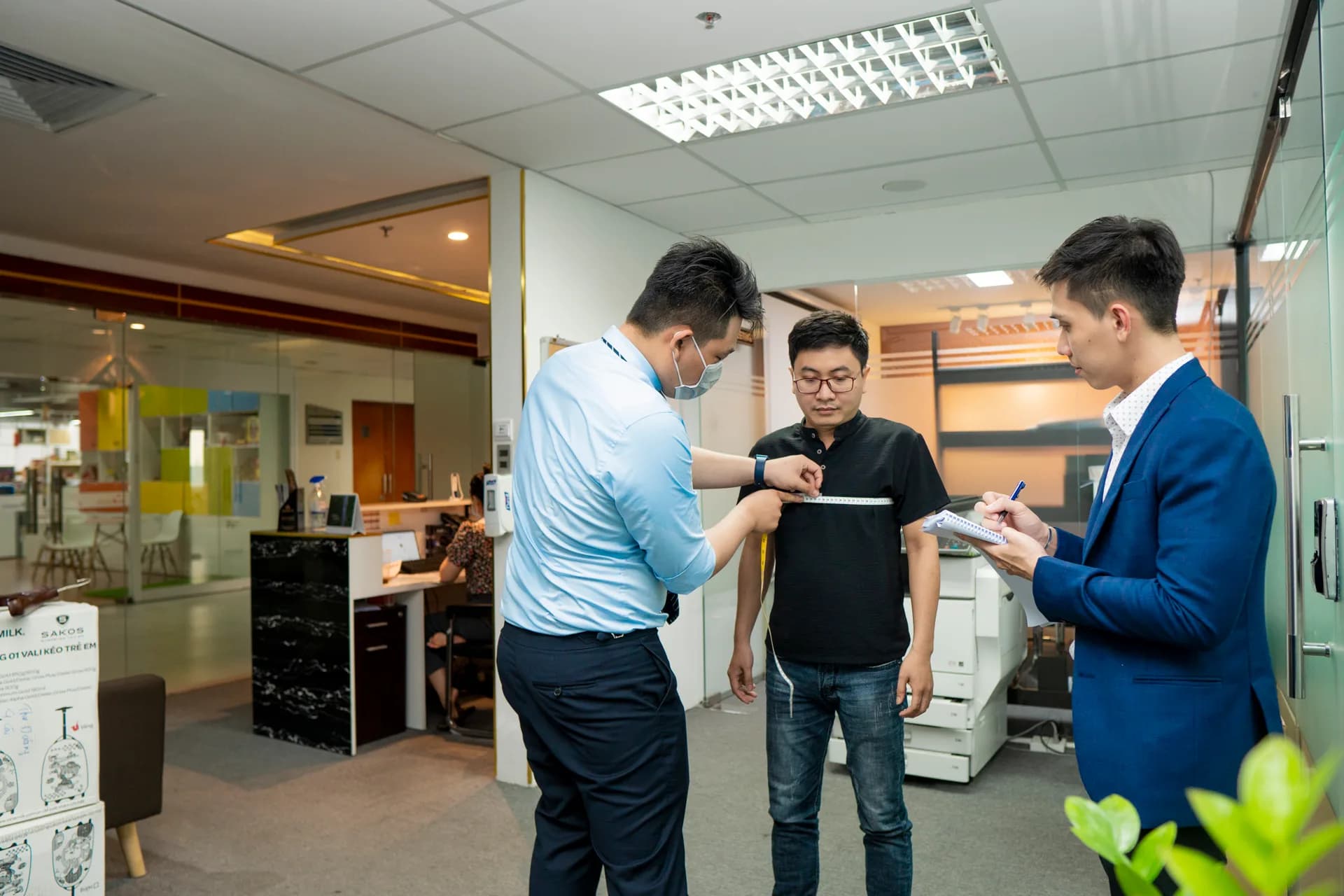 Đo vòng ngực cho nhân viên nam MEDEZE, nhân viên ghi số đo