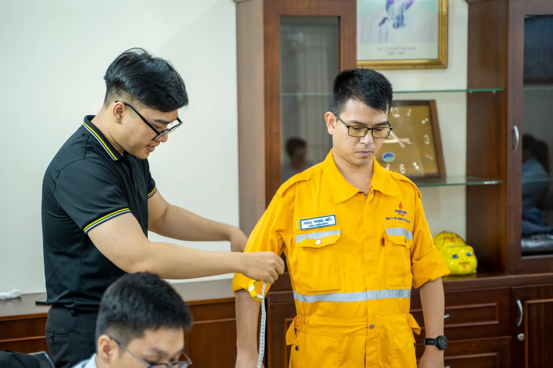 Đo bắp tay cho công nhân đang mặc áo bảo hộ PV GAS