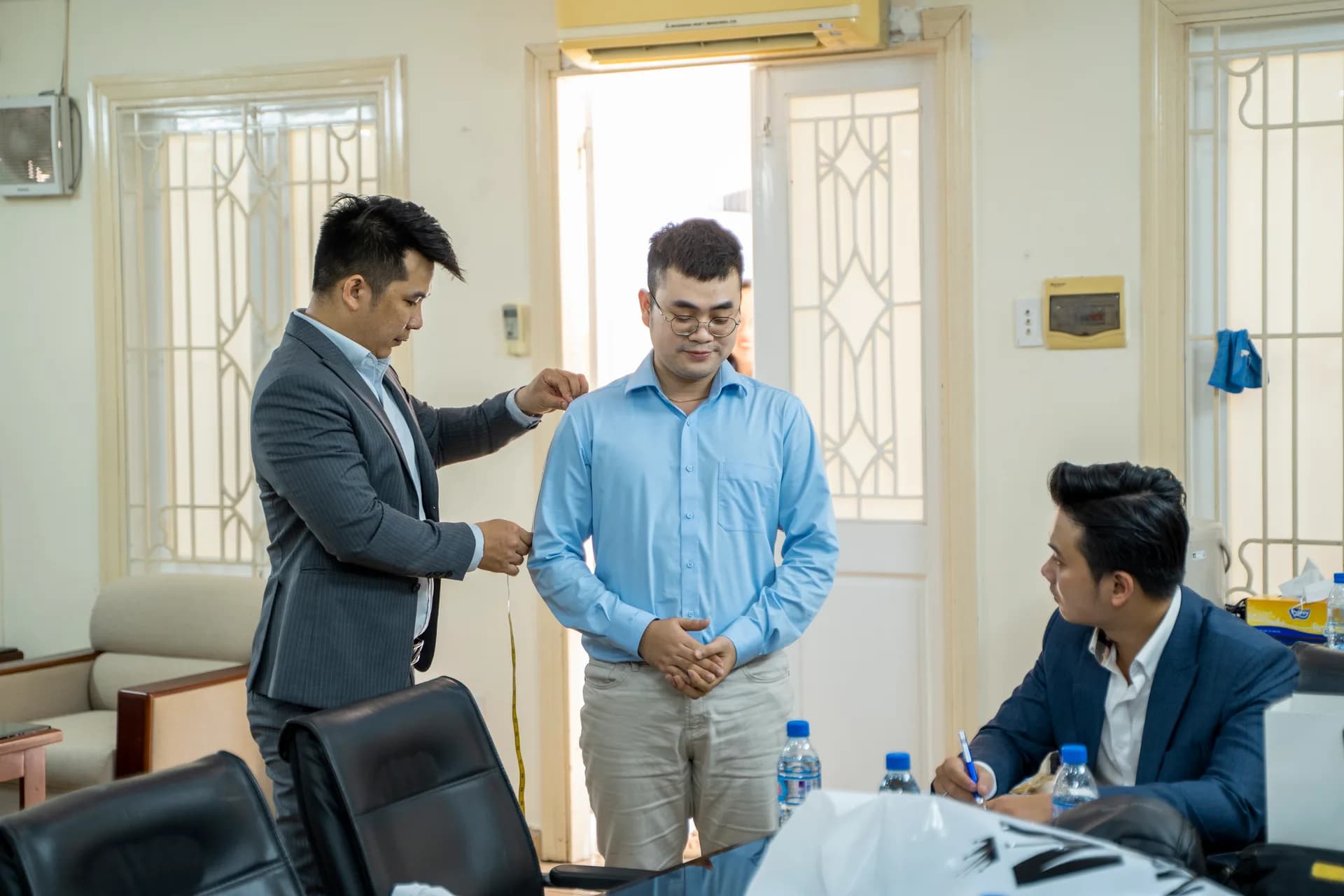 Đo vai cho nhân viên nam áo sơ mi xanh