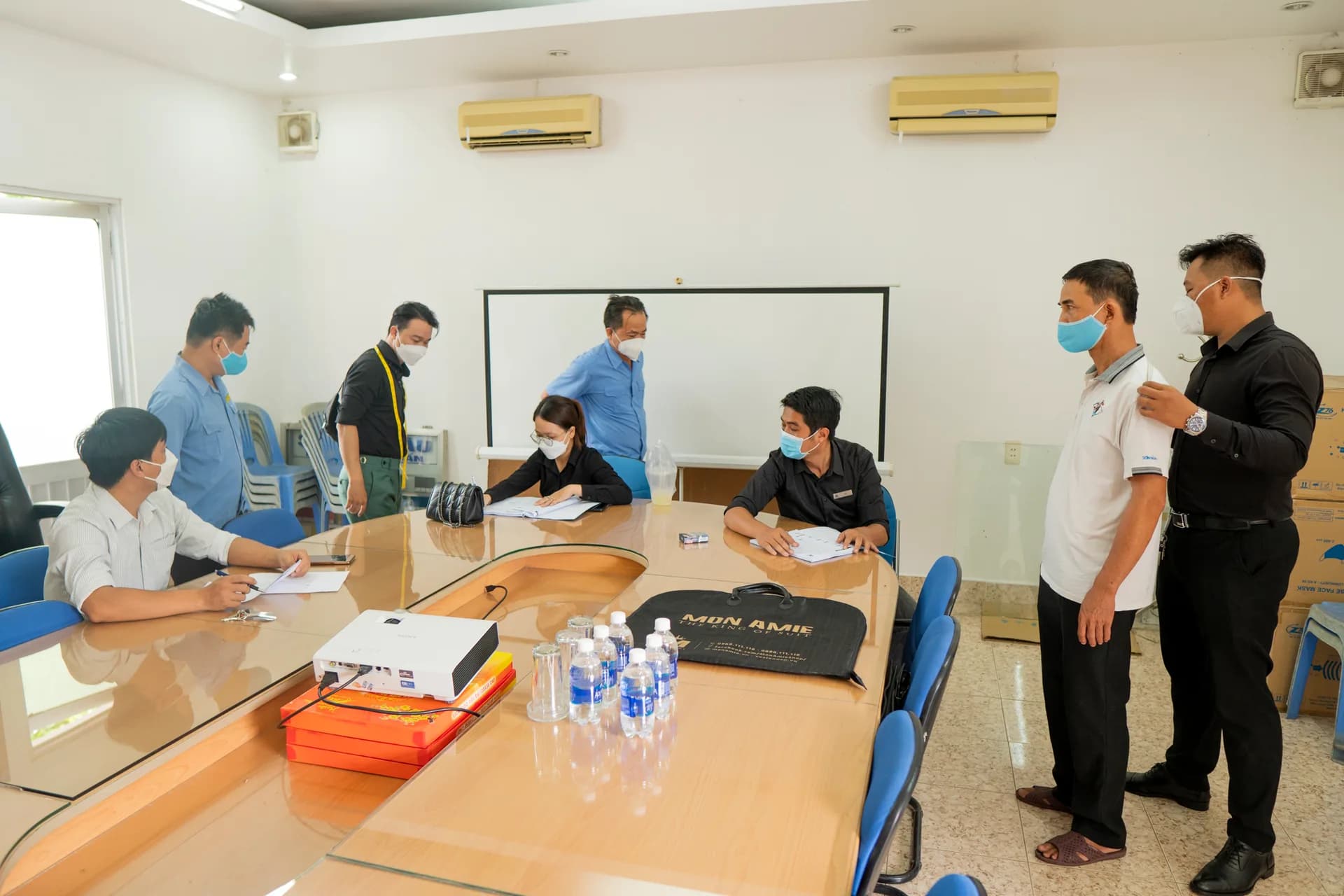 Phòng họp công ty thành nơi đo đồng phục veston, nhân viên lần lượt vào đo số đo cho đồng phục văn phòng cao cấp