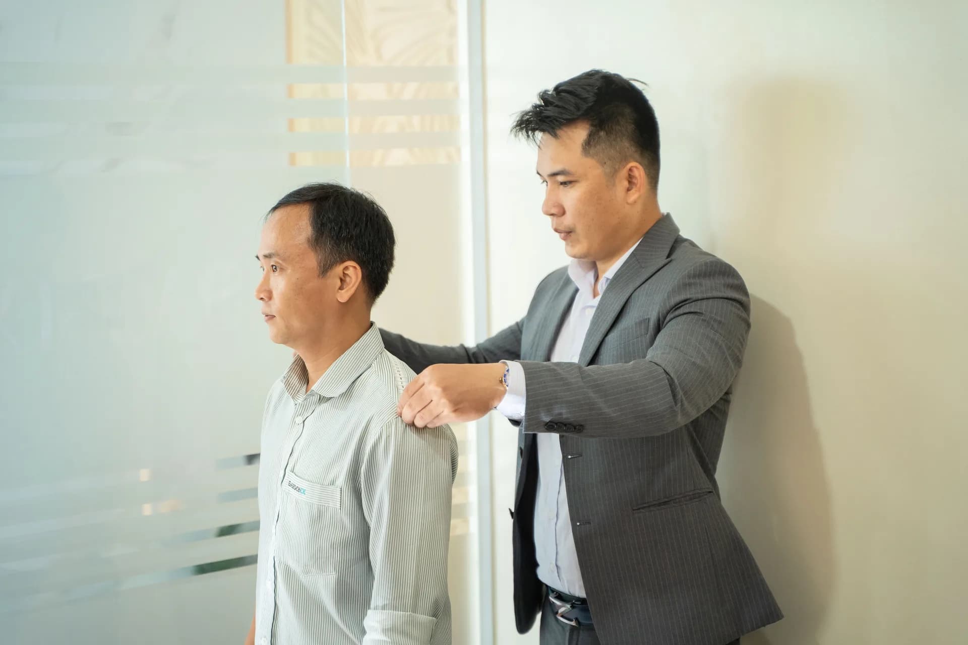 Đo vai cho nhân viên nam mặc áo sơ mi logo SAIGONIX