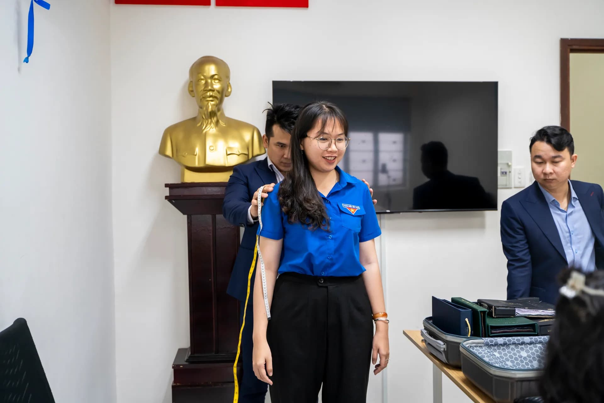 Đo vai cho cán bộ đoàn nữ mặc áo thanh niên xanh