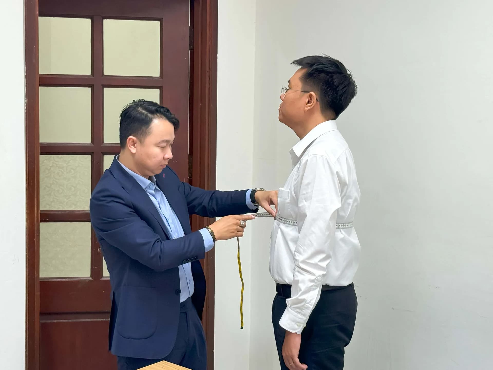 Đo vòng eo cho cán bộ đoàn nam trong phòng làm việc