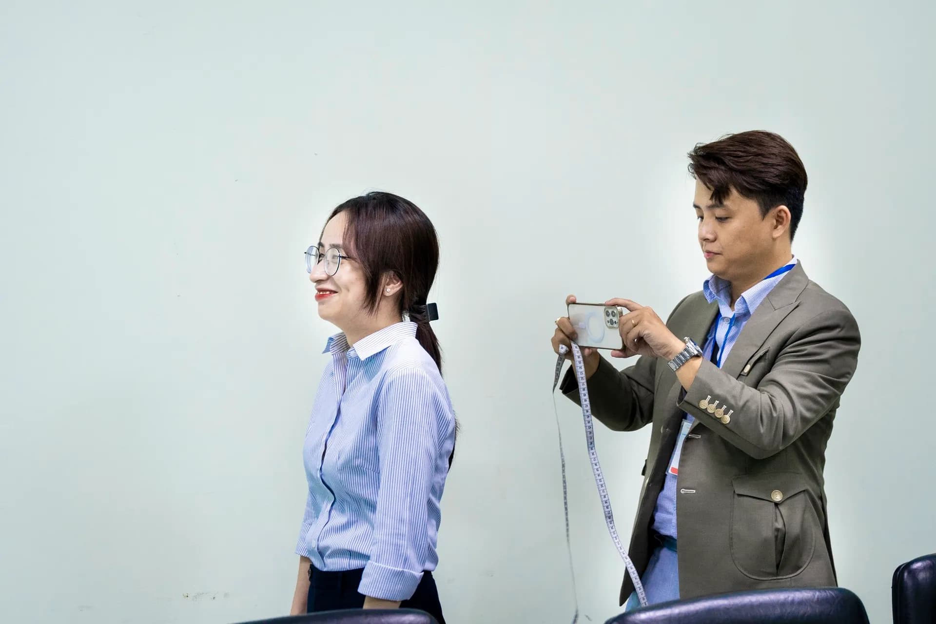 Chụp lại dáng đứng của nữ nhân viên khi lấy số đo, nụ cười tự nhiên