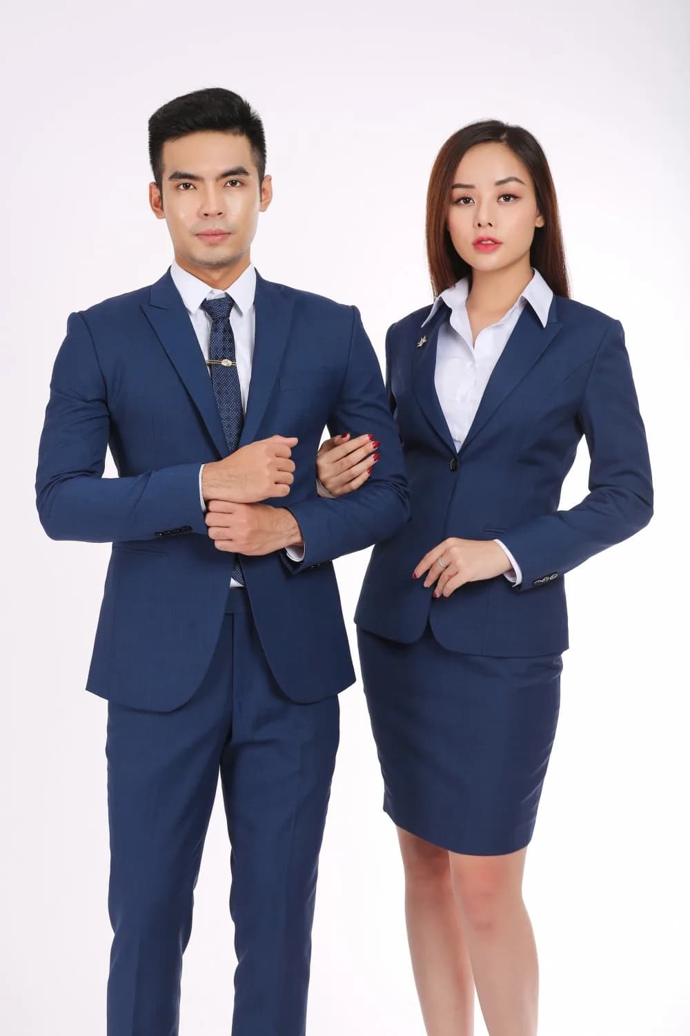 Suit nam và vest nữ cùng gam xanh, sơ mi trắng, cà vạt chấm bi