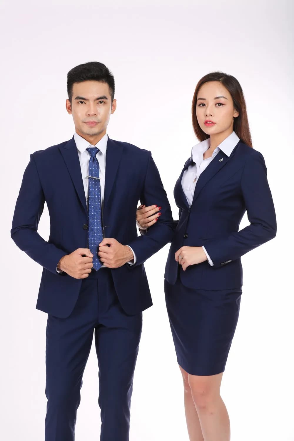 Bộ đôi vest xanh navy đậm, cà vạt xanh chấm bi, dáng đứng tự tin