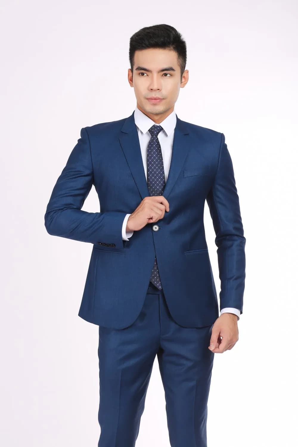 Nam suit xanh navy cận cảnh, cà vạt đồng màu, dáng tự tin