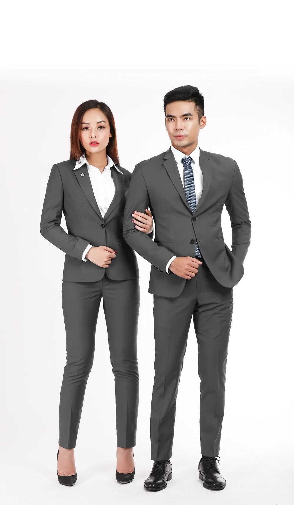 Cặp đồng phục công sở xám, nam nữ đứng cạnh nhau nền trắng