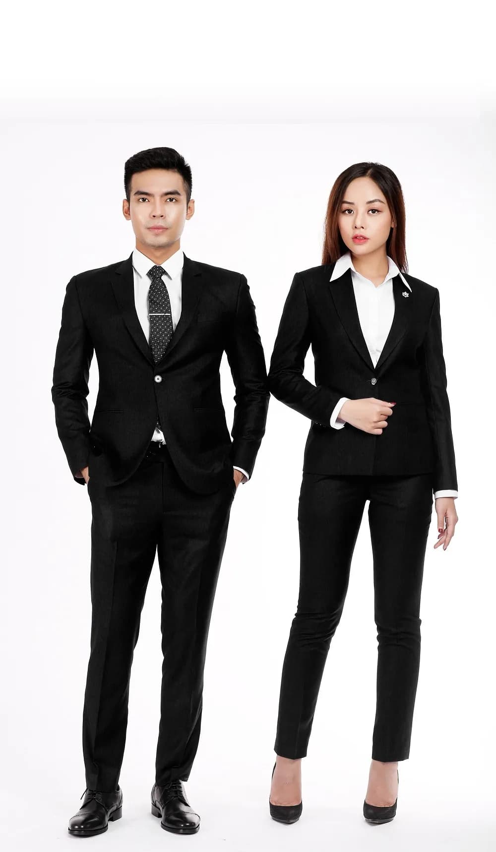 Cặp đồng phục công sở đen, nam nữ đứng cạnh nhau nền trắng