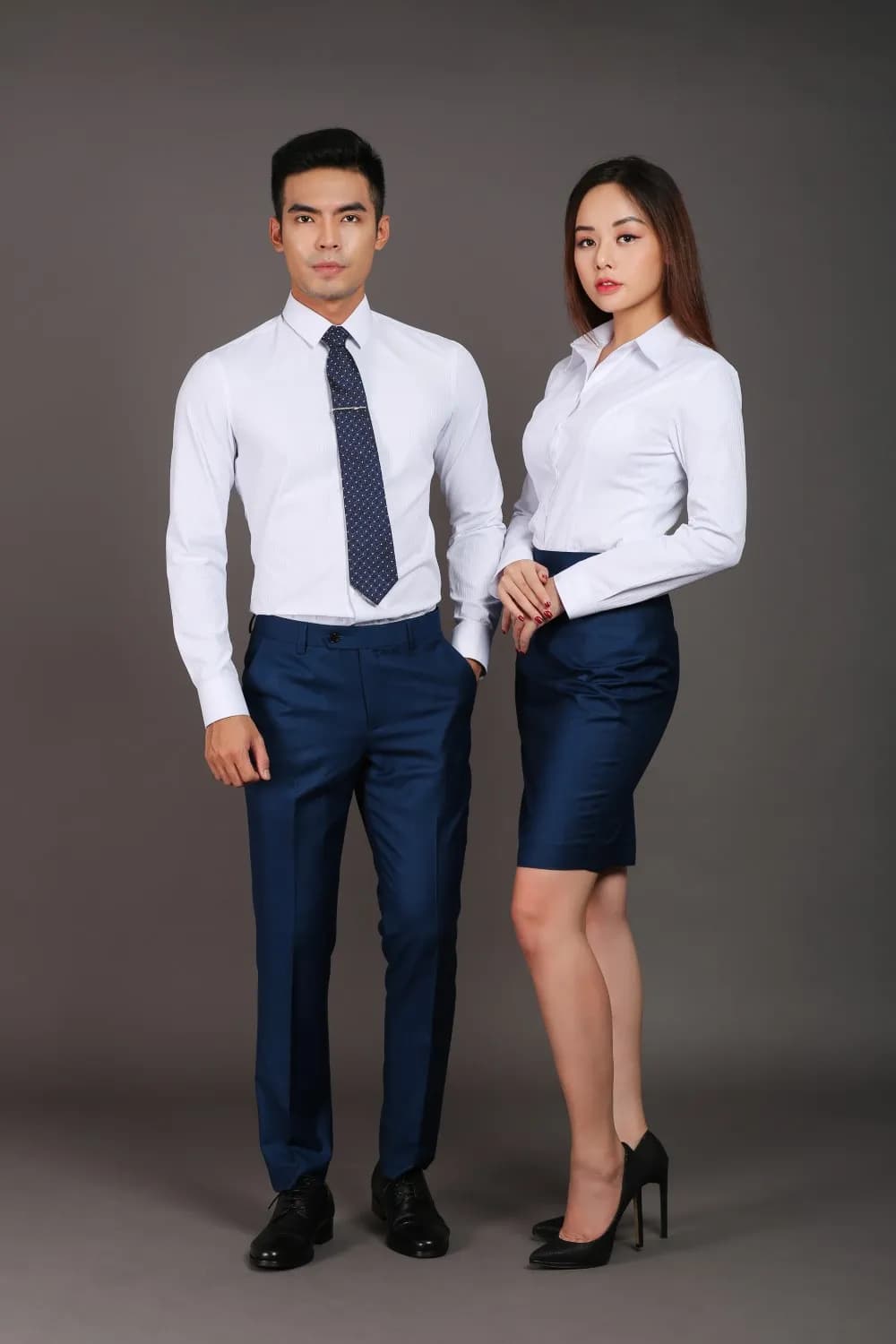 Cặp đồng phục sơ mi trắng, cà vạt navy, quần và chân váy xanh navy, nền xám