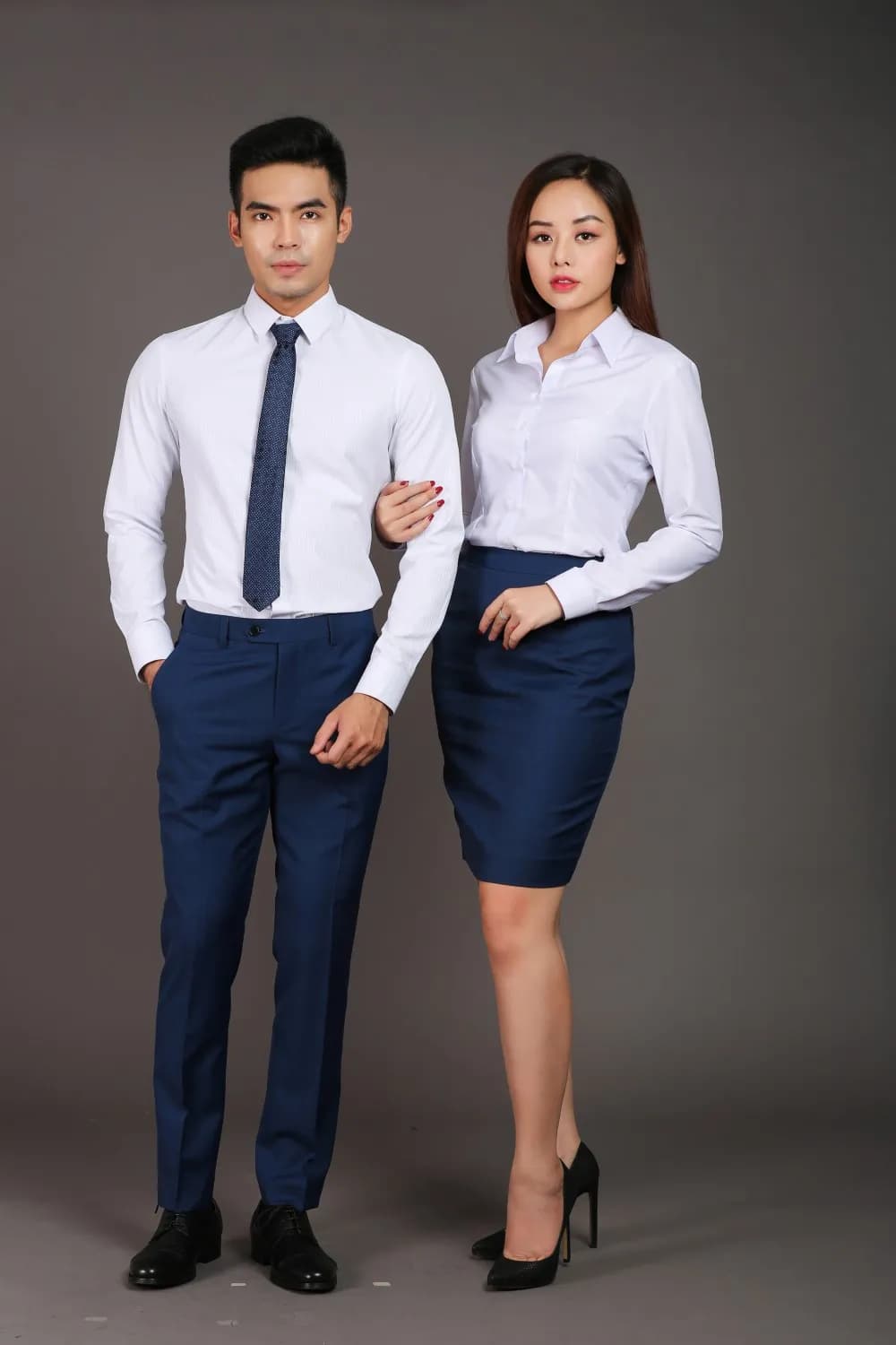 Cặp đồng phục sơ mi trắng cà vạt navy, quần và chân váy navy nền xám