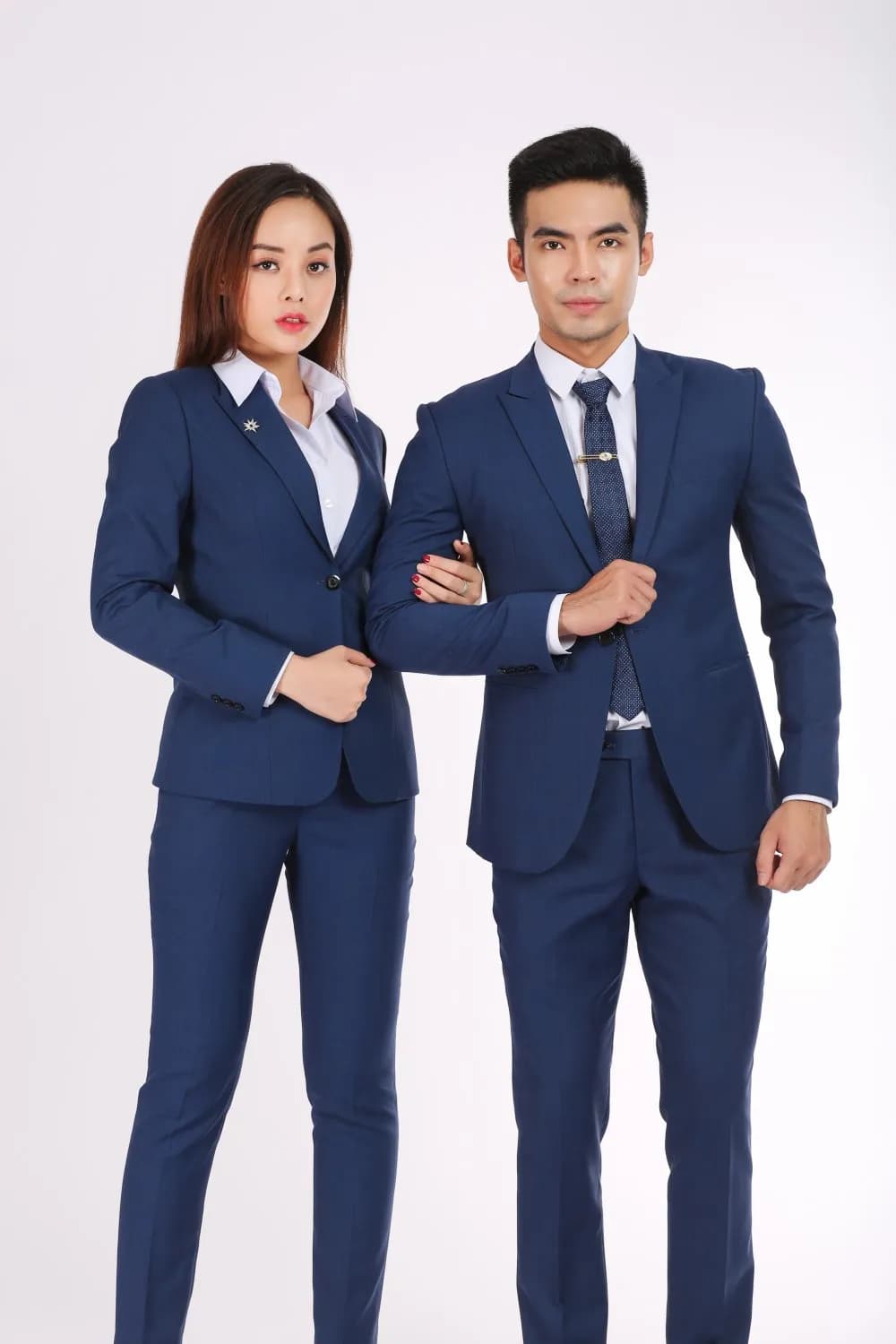 Cặp đồng phục xanh navy quần tây, nam nữ khoác tay cận cảnh