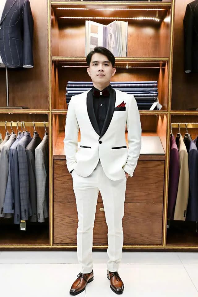 Tuxedo trắng ve đen, sơ mi đen, nơ đỏ đô, minh họa bộ vest chú rể may đo và chi phí theo dòng vải