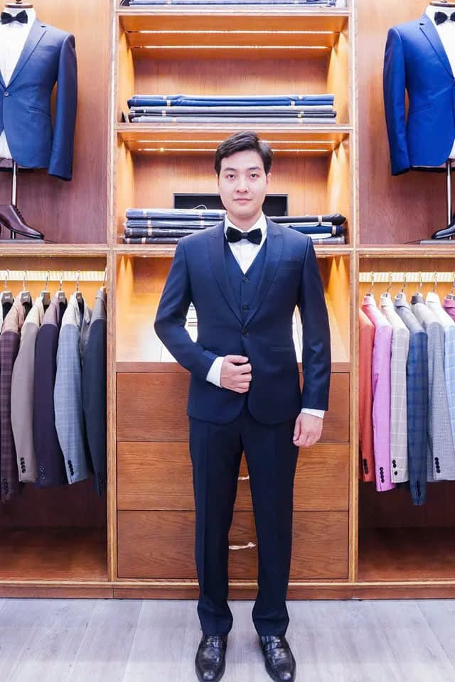 Chàng trai mặc vest navy ba mảnh, nơ đen lịch lãm, minh họa chú rể mặc vest màu gì đẹp