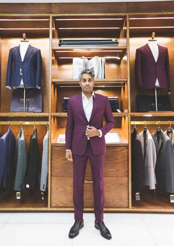 Quý ông mặc vest đỏ mận, sơ mi trắng trong showroom gỗ ấm, hình ảnh tiệm may vest gần đây