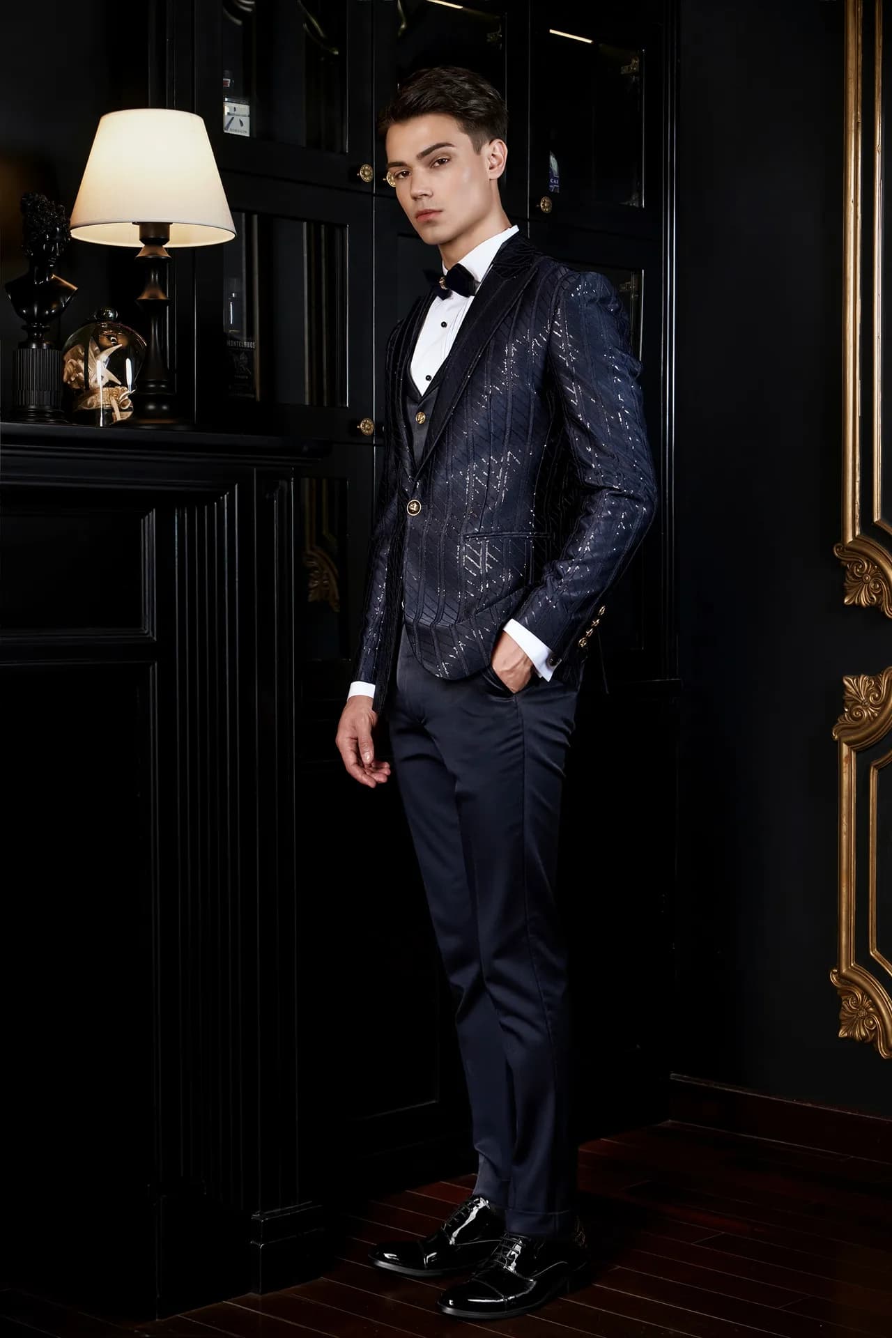 Suit xanh navy vải dệt kim tuyến chéo, ve nhung, nơ đen trong phòng cổ điển, ví dụ bộ vest cần ủi đúng cách