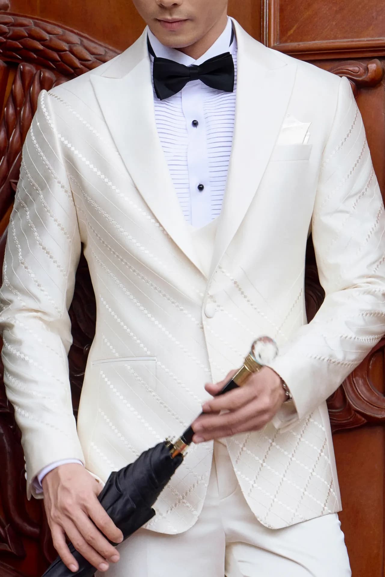 Tuxedo trắng kem cận cảnh, nơ đen, tay cầm ô