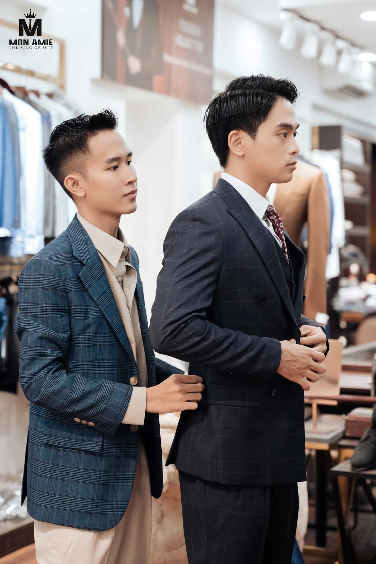 Thợ may chỉnh vai áo vest caro đậm cho khách tại giá treo vest