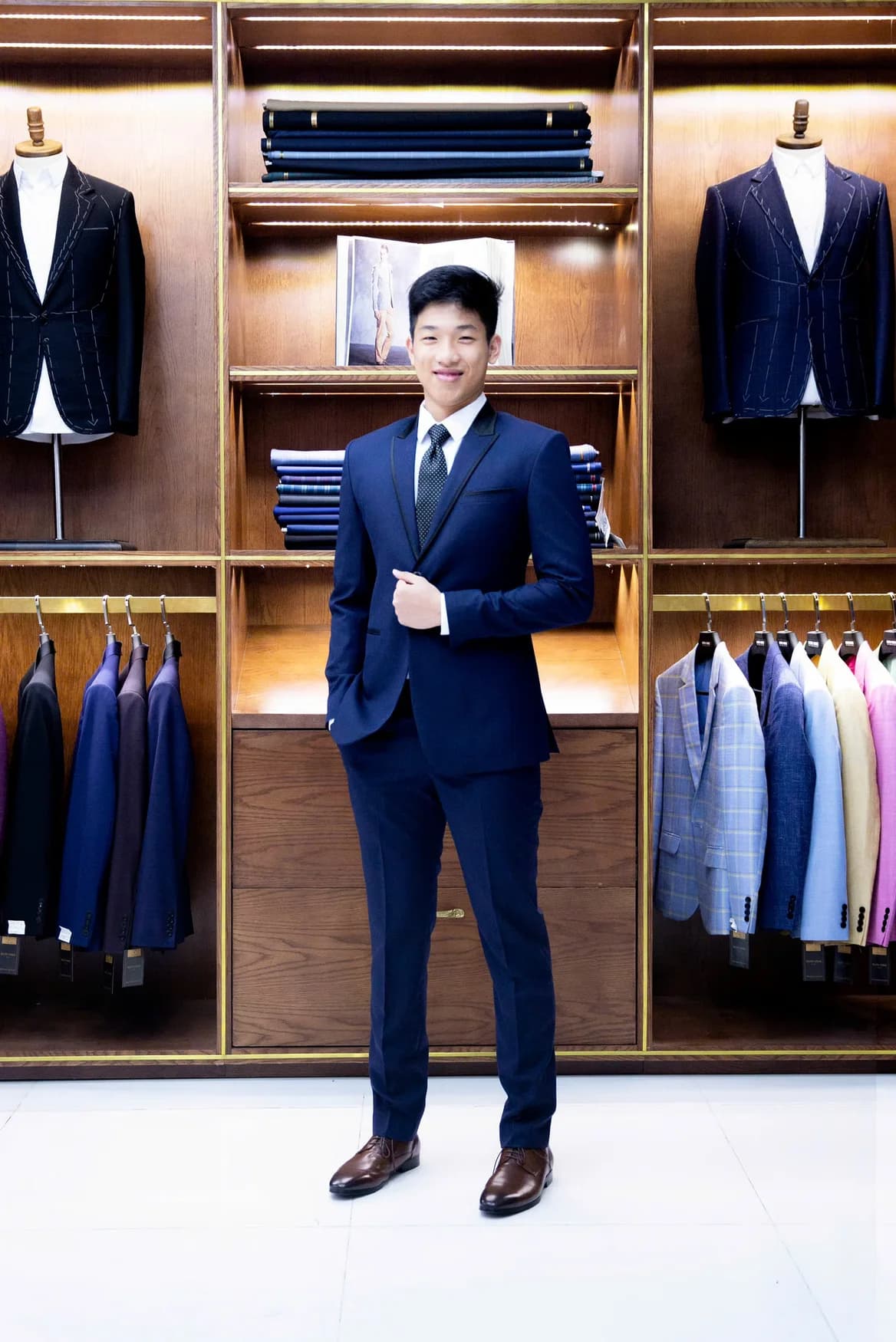 Chàng trai trẻ vest navy viền đen, cà vạt chấm bi