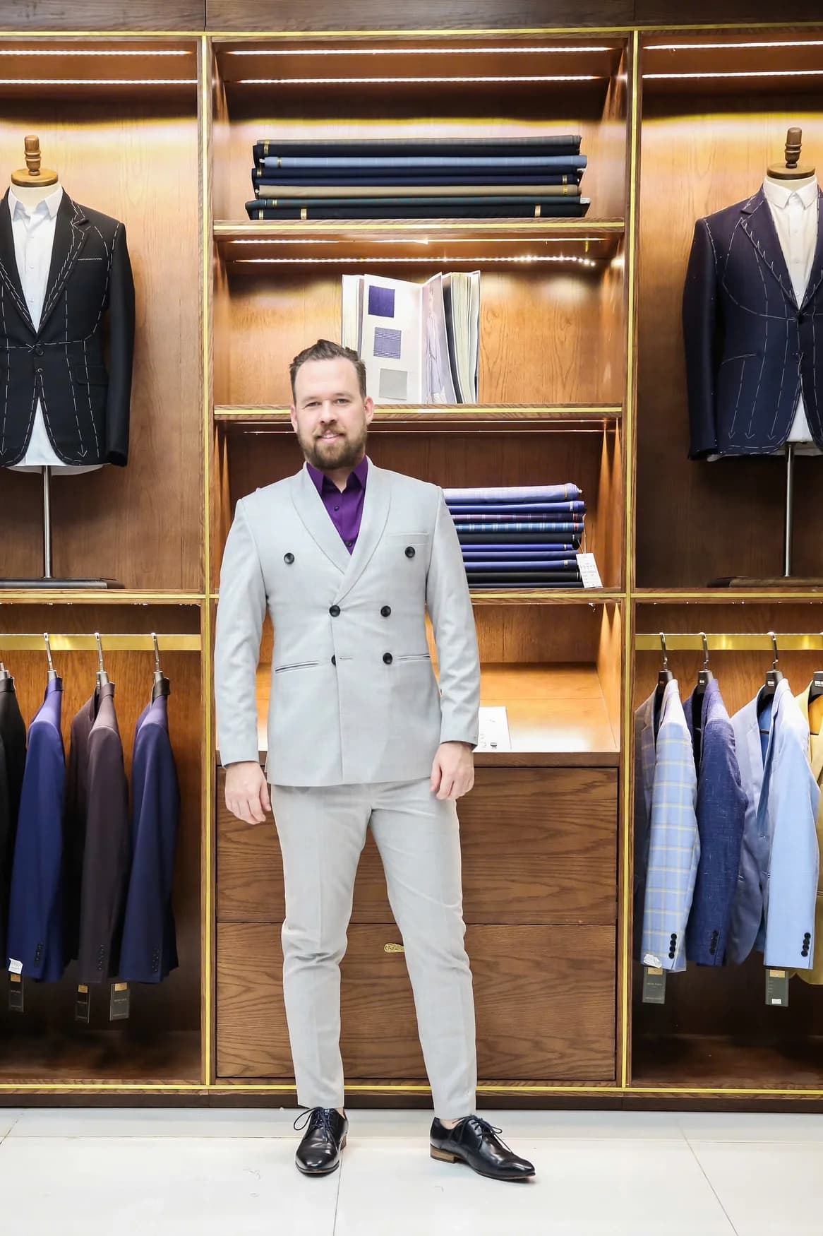 Quý ông Tây vest xám sáng, sơ mi tím, showroom gỗ