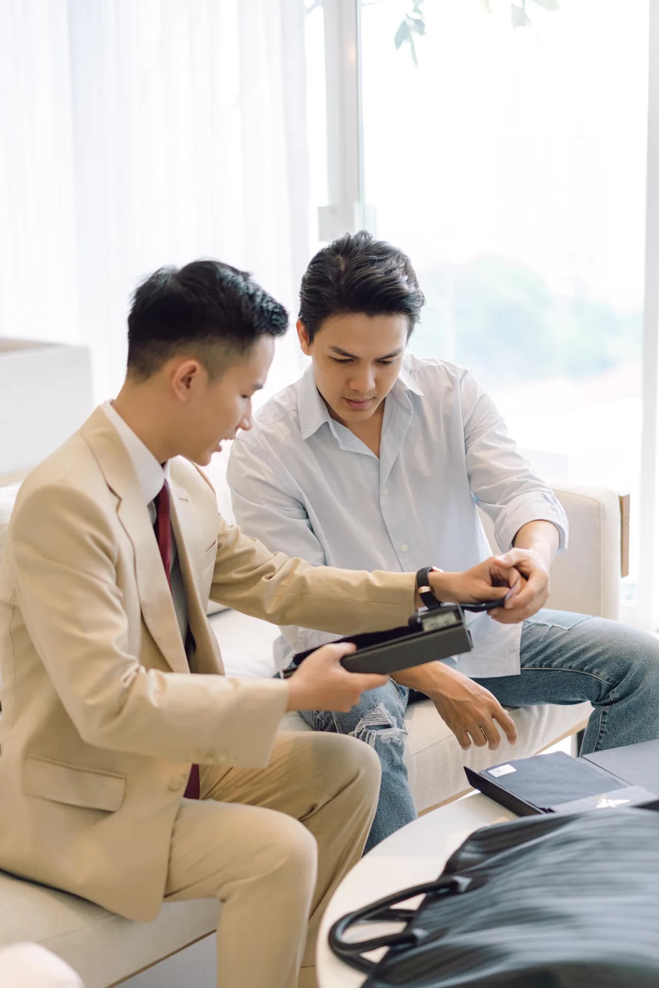 Nghệ nhân giới thiệu mẫu vải cho khách bên khung cửa sáng