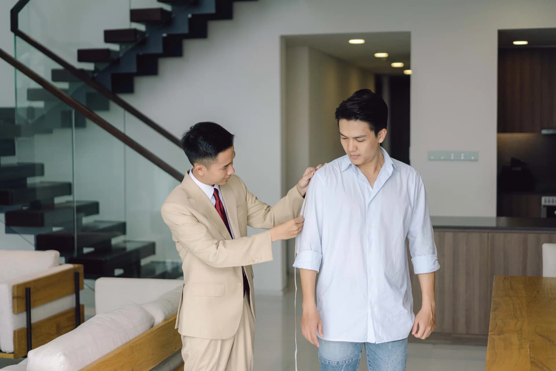 Nghệ nhân đo vai và chiều dài tay áo cho khách trong căn hộ