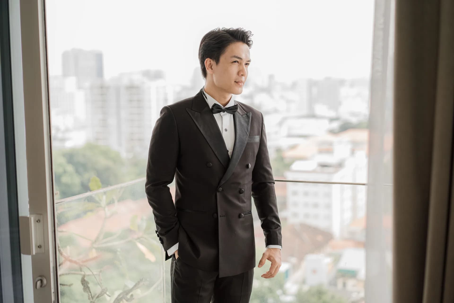 Nhìn xa ngoài ban công trong bộ tuxedo hai hàng khuy