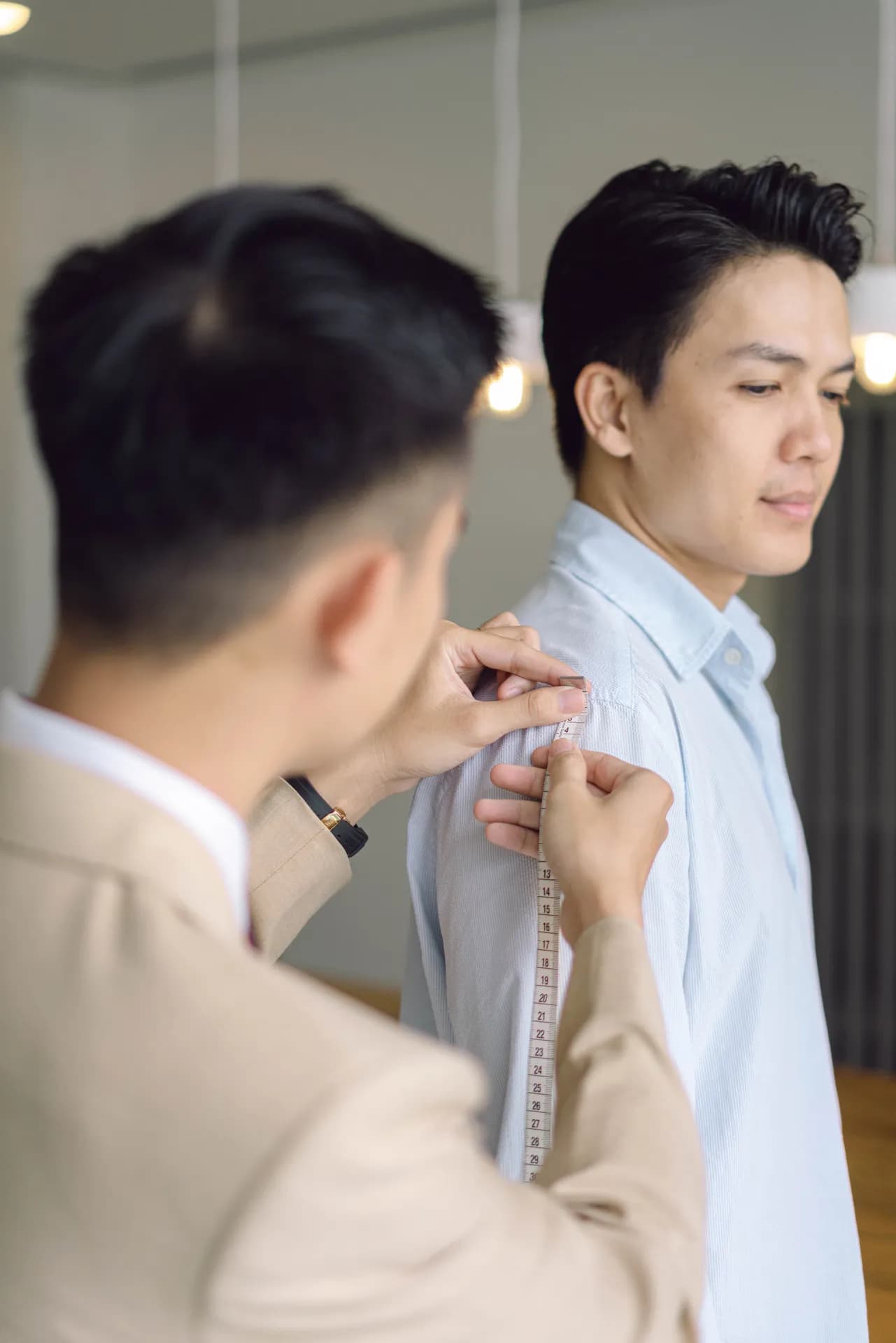 Thợ may đo vai áo cho khách, vest màu be dáng thẳng
