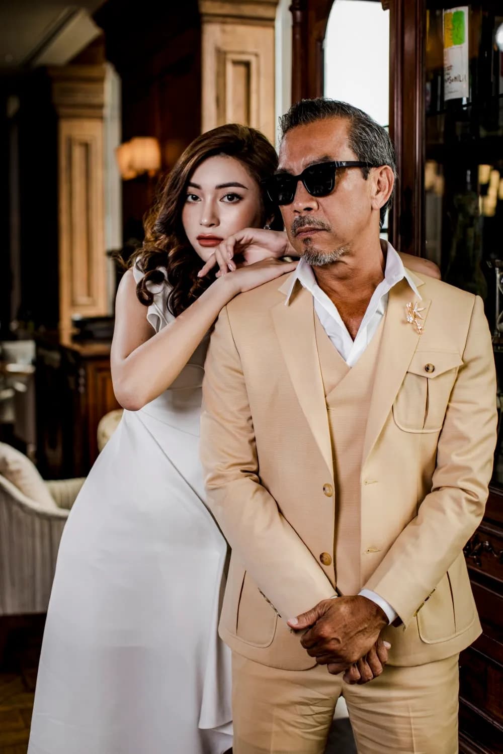 Suit ba mảnh be vàng, kính râm, cùng người mẫu váy trắng tựa vai