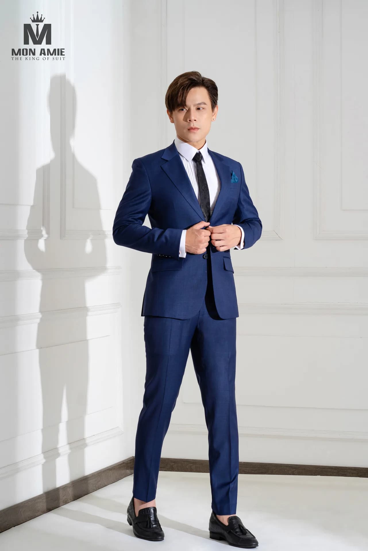 Suit xanh navy một hàng khuy, vải ô chìm, cà vạt đen và khăn cài túi, minh họa màu vest nam đẹp và dễ phối nhất