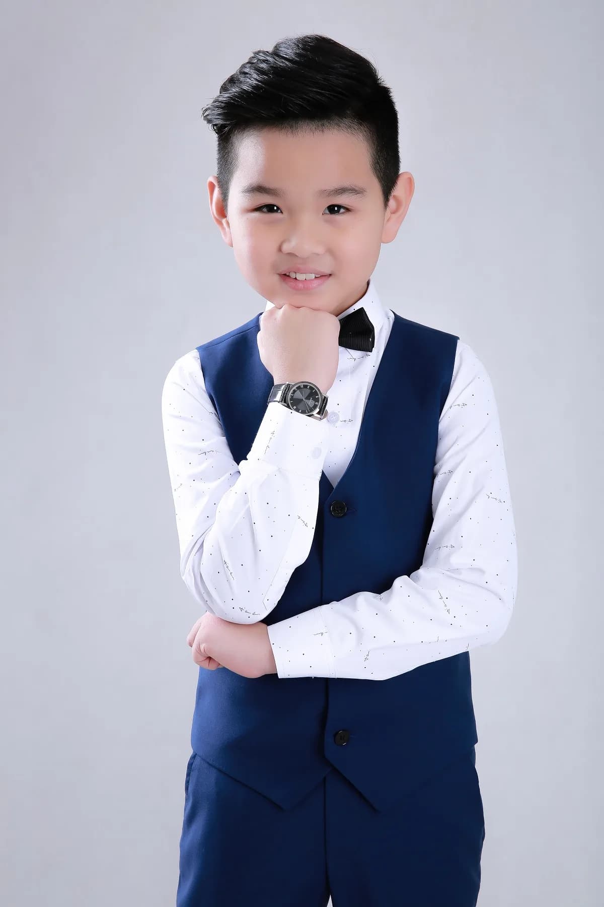 Bé tựa cằm đáng yêu, sơ mi trắng chấm nhỏ phối gile navy thanh lịch