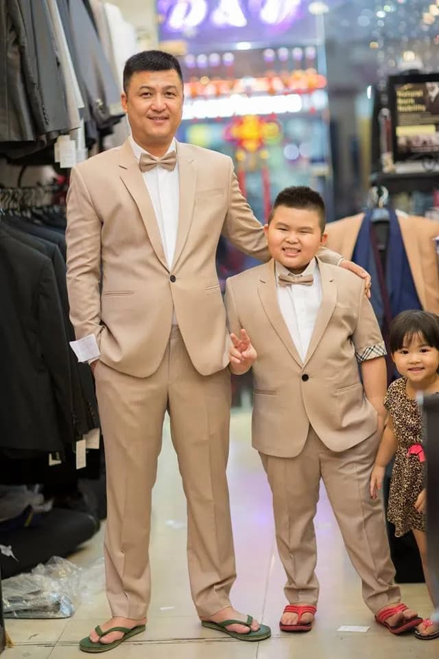 Người lớn và cậu bé cùng diện suit màu be, nơ be tinh tế