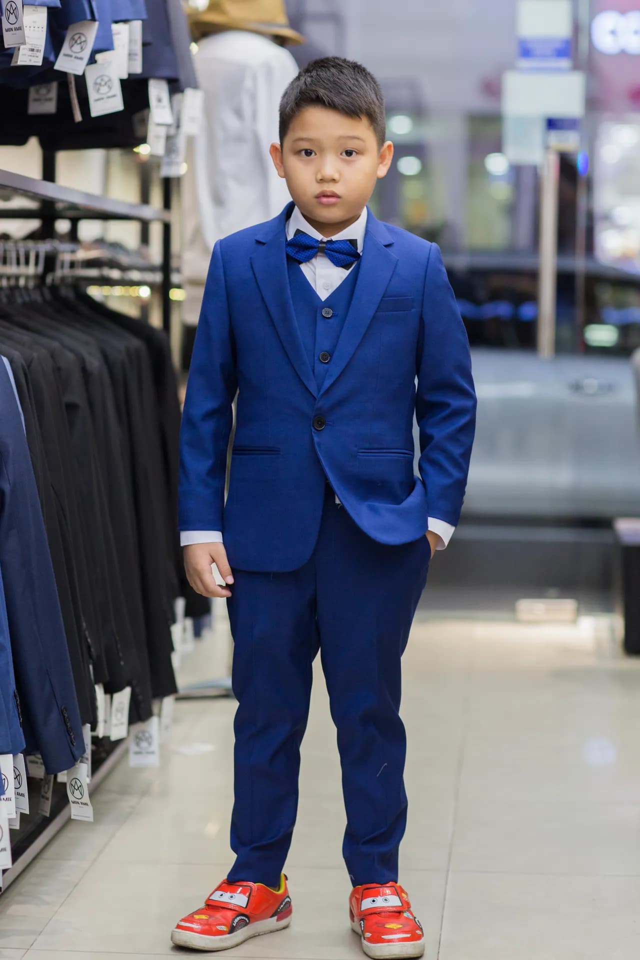 Cậu bé trong bộ suit ba mảnh xanh hoàng gia, nơ chấm bi nổi bật