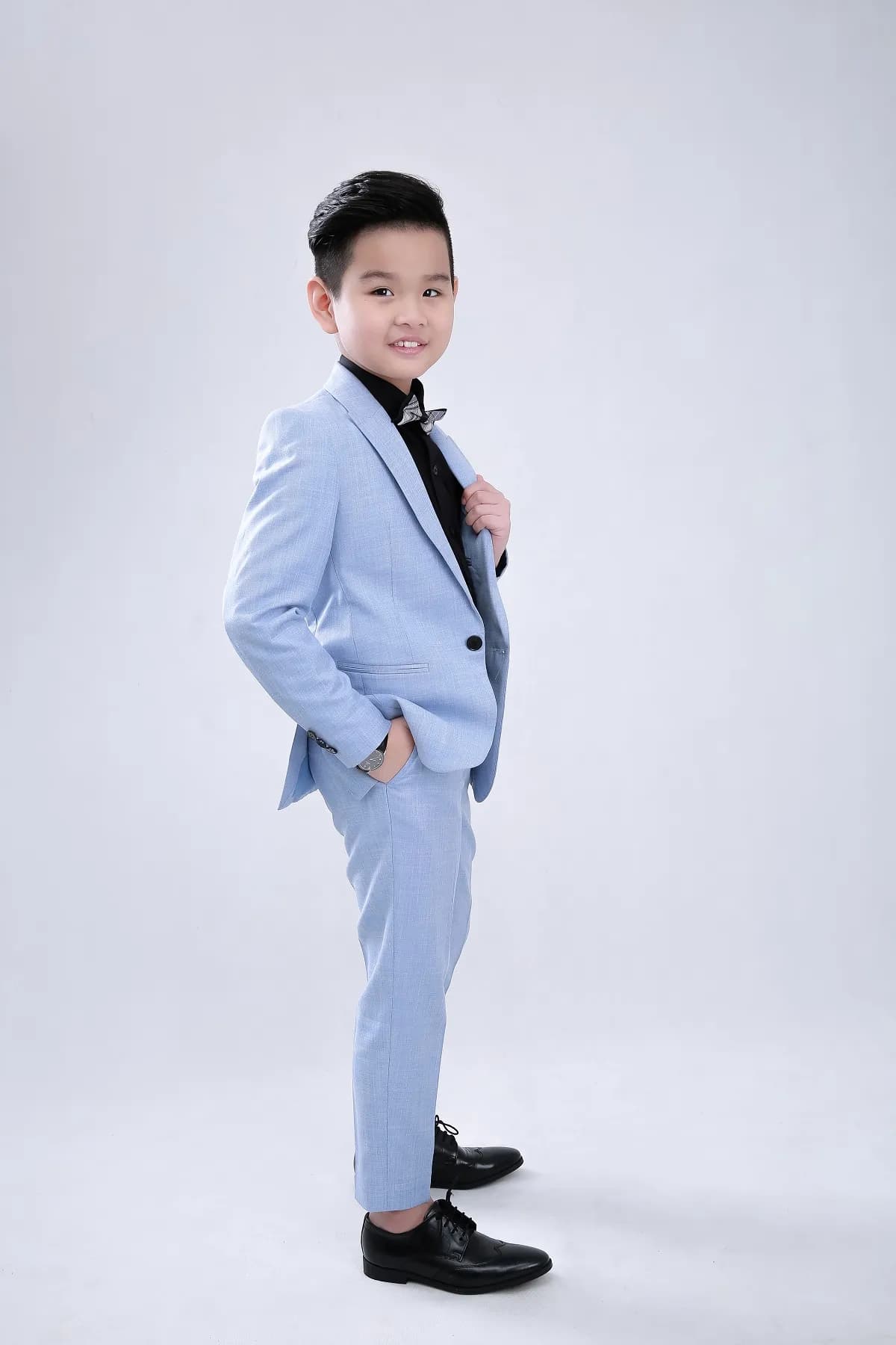 Dáng nghiêng thoải mái trong suit xanh pastel, tay đút túi tự nhiên