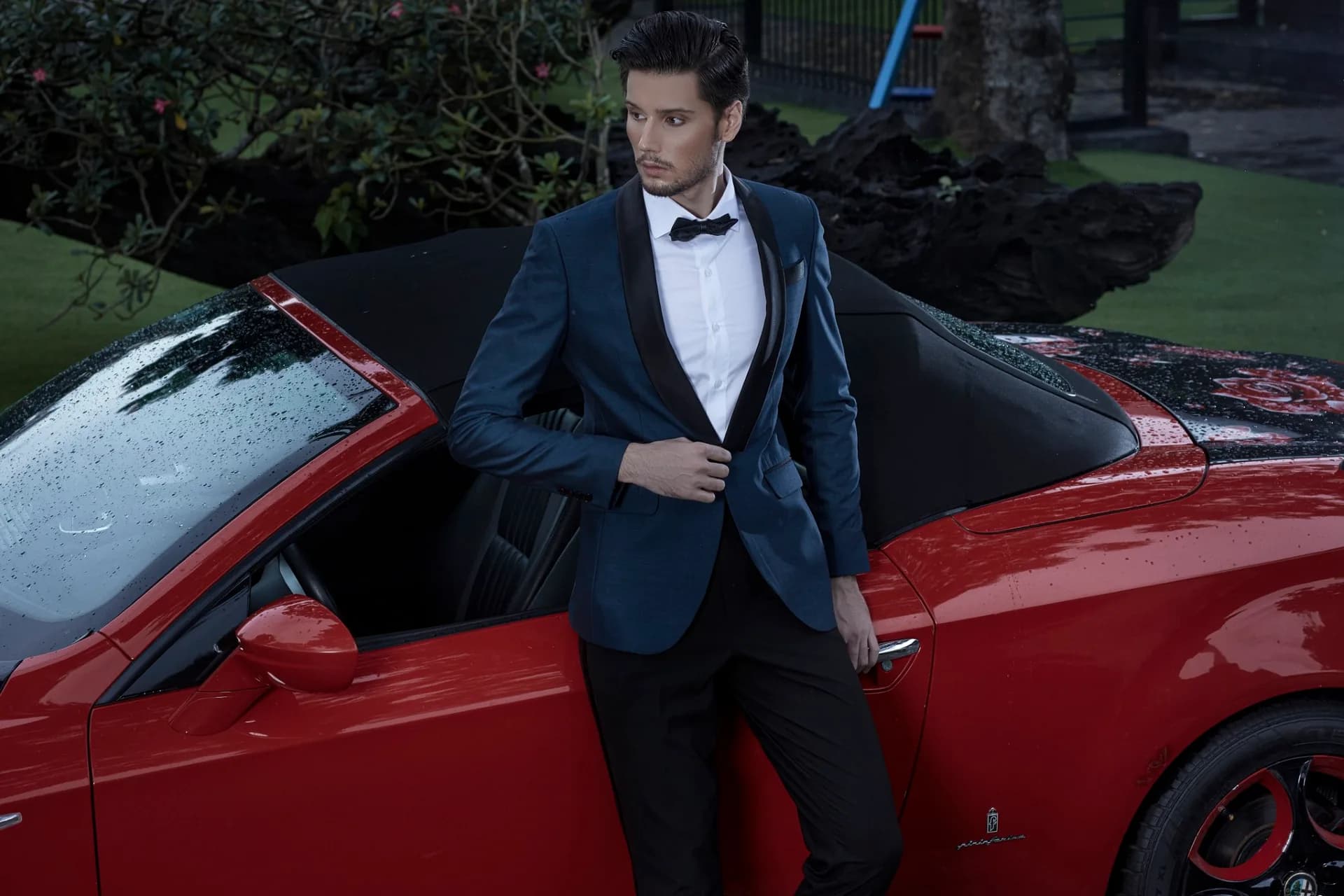 Tuxedo xanh ve đen bên chiếc xe mui trần màu đỏ