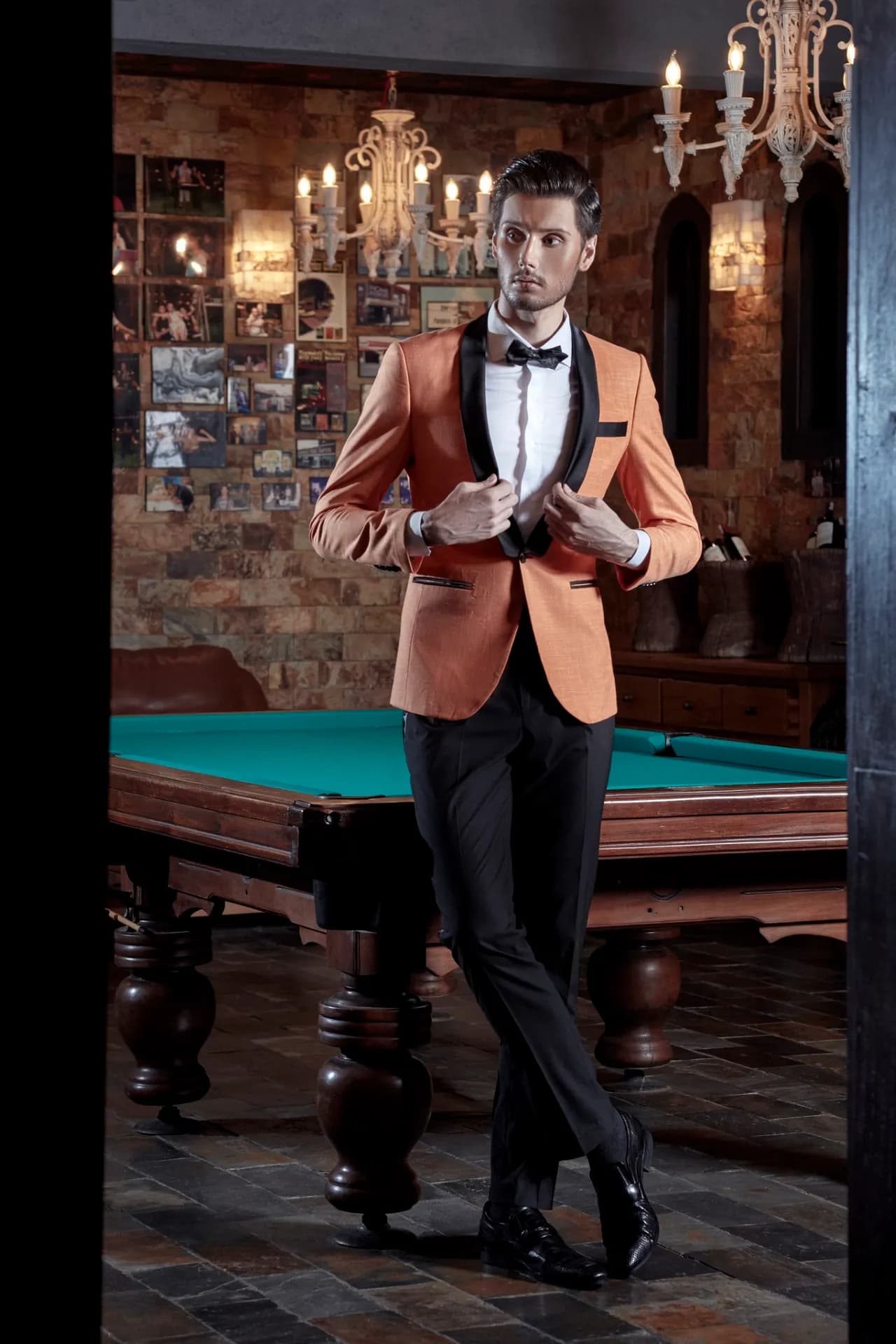 Blazer cam đất ve nhung đen, nơ đen, đứng bên bàn bi-a trong phòng gạch