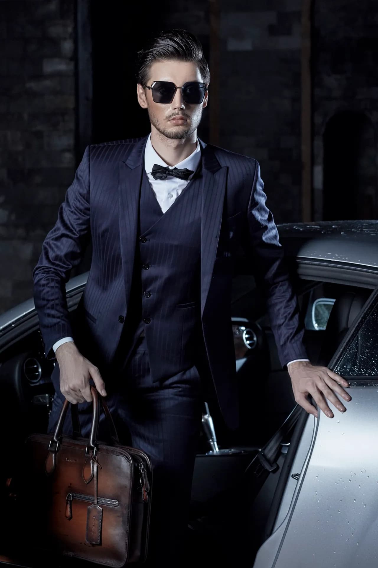 Suit ba mảnh navy kẻ sọc, kính râm, cặp da nâu, bước xuống xe sang