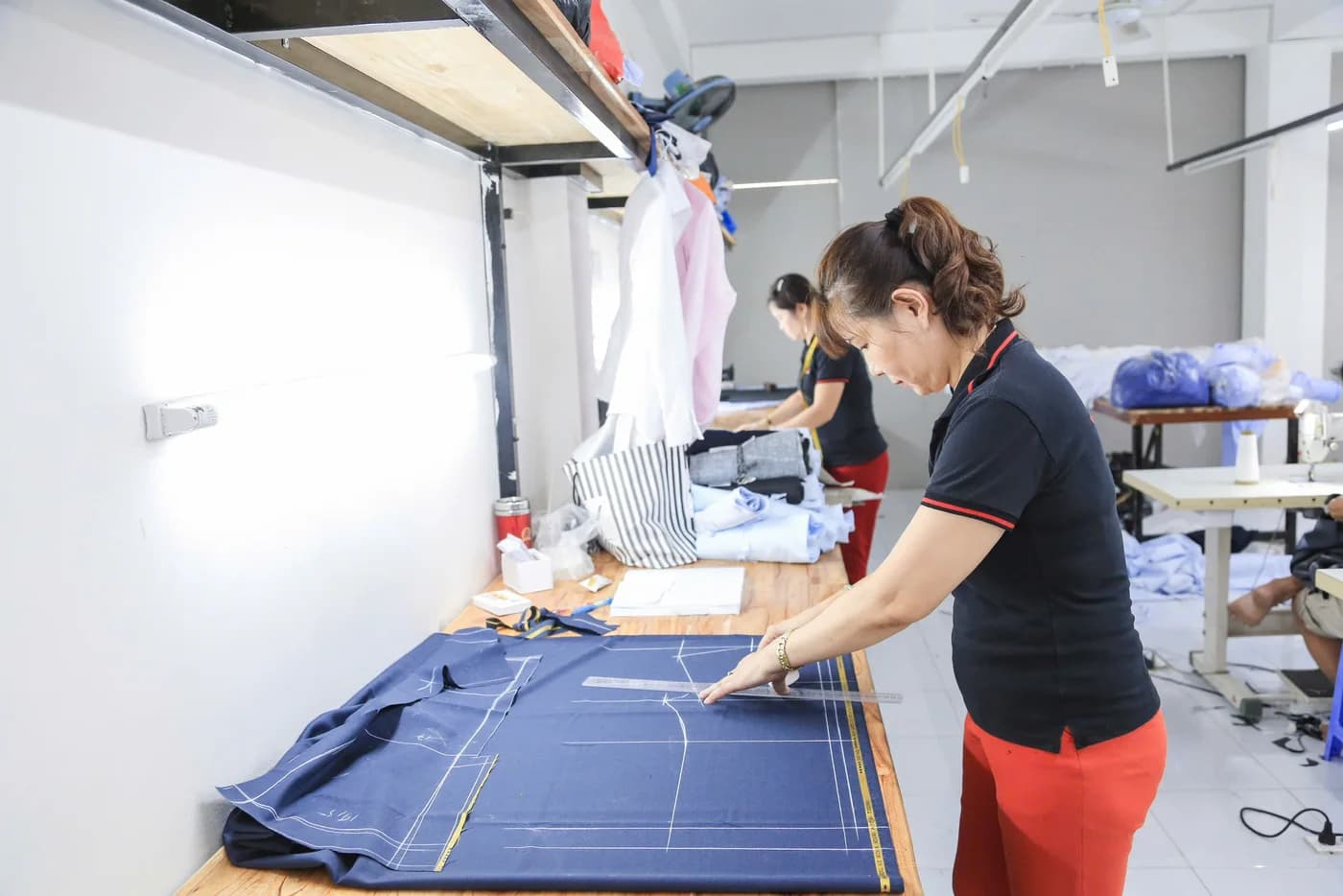 Thợ nữ áo đen quần đỏ kẻ rập trên vải xanh navy