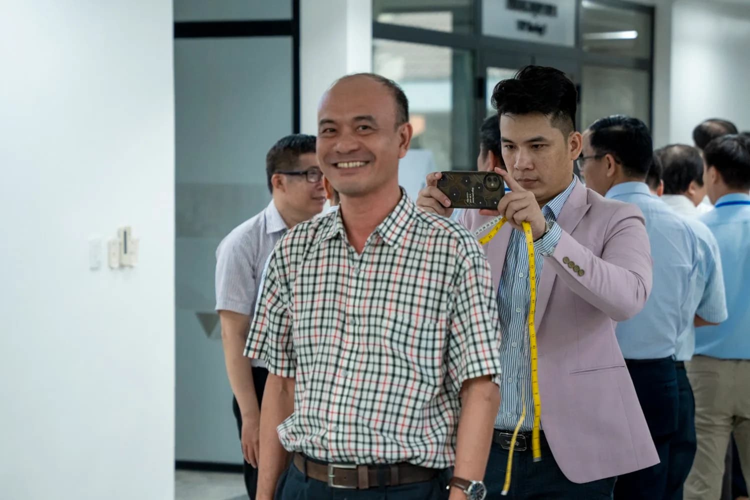 Cán bộ nhà trường cười tươi trong lúc chờ đến lượt đo đồng phục