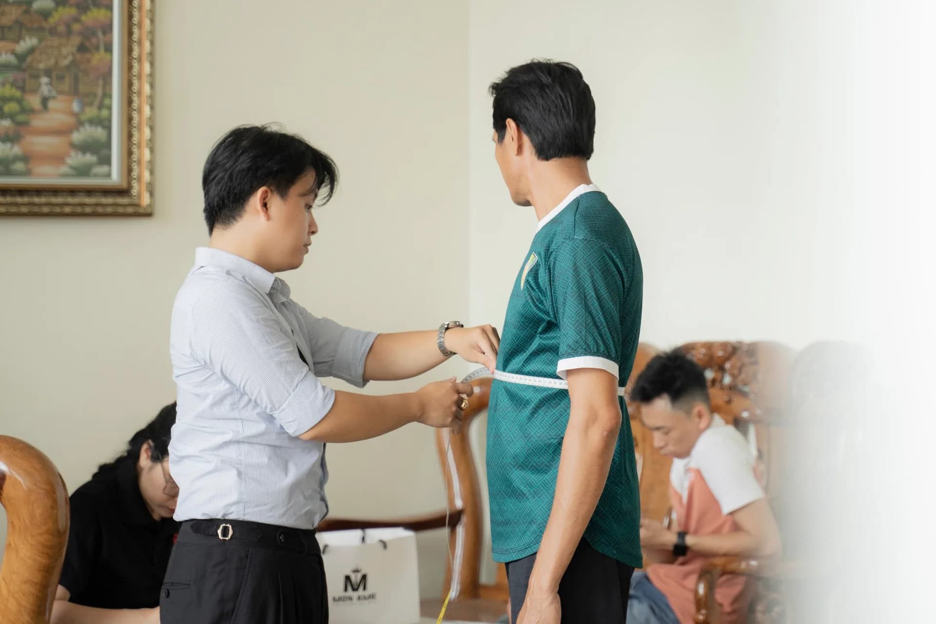 Đo vòng eo cho cầu thủ trong áo thi đấu xanh lá