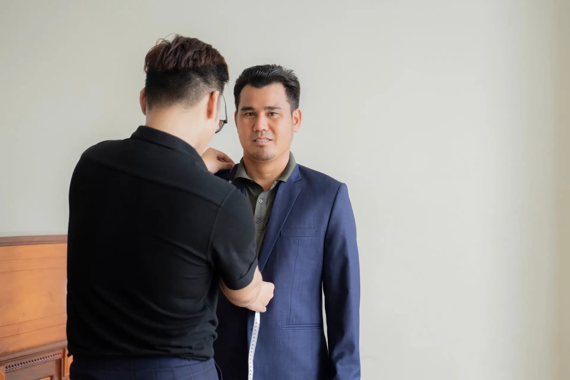 Thử áo vest xanh navy, thợ đo chiều dài áo