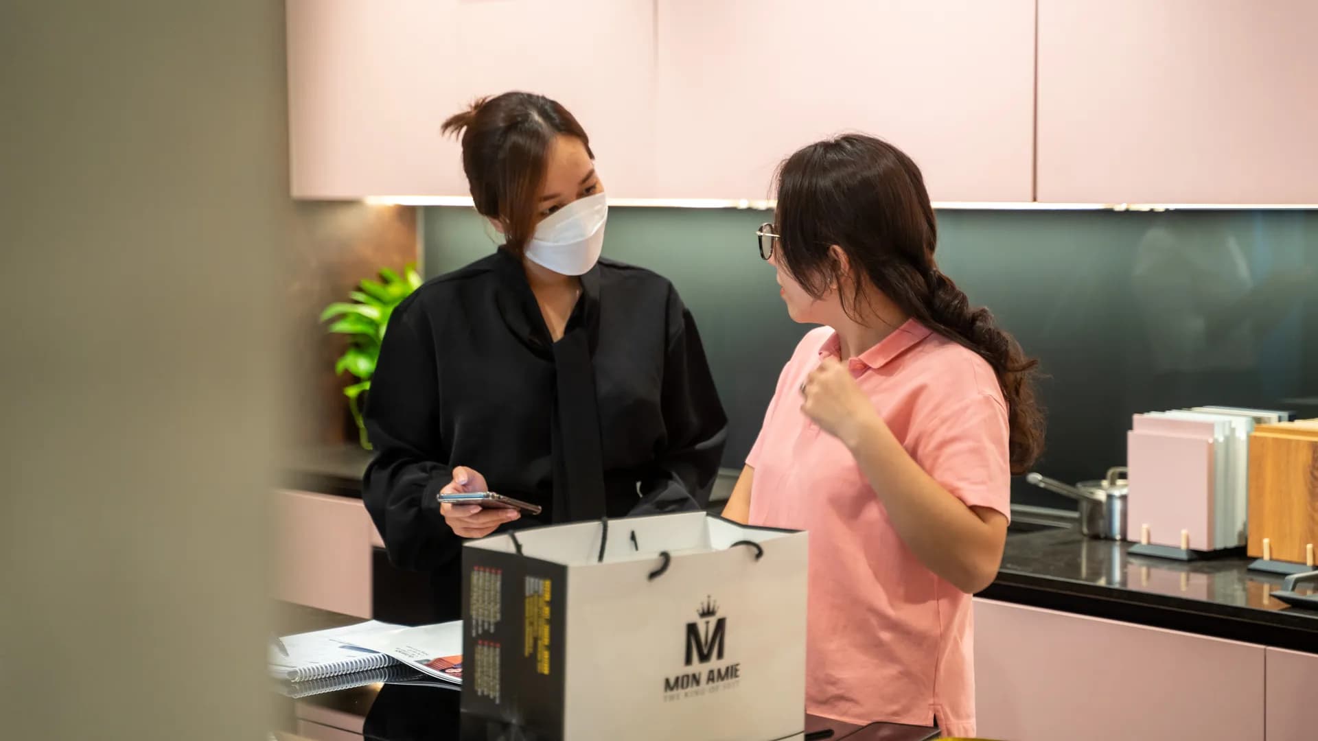 Trao đổi nhu cầu đồng phục với đại diện công ty, có túi Mon Amie trên bàn