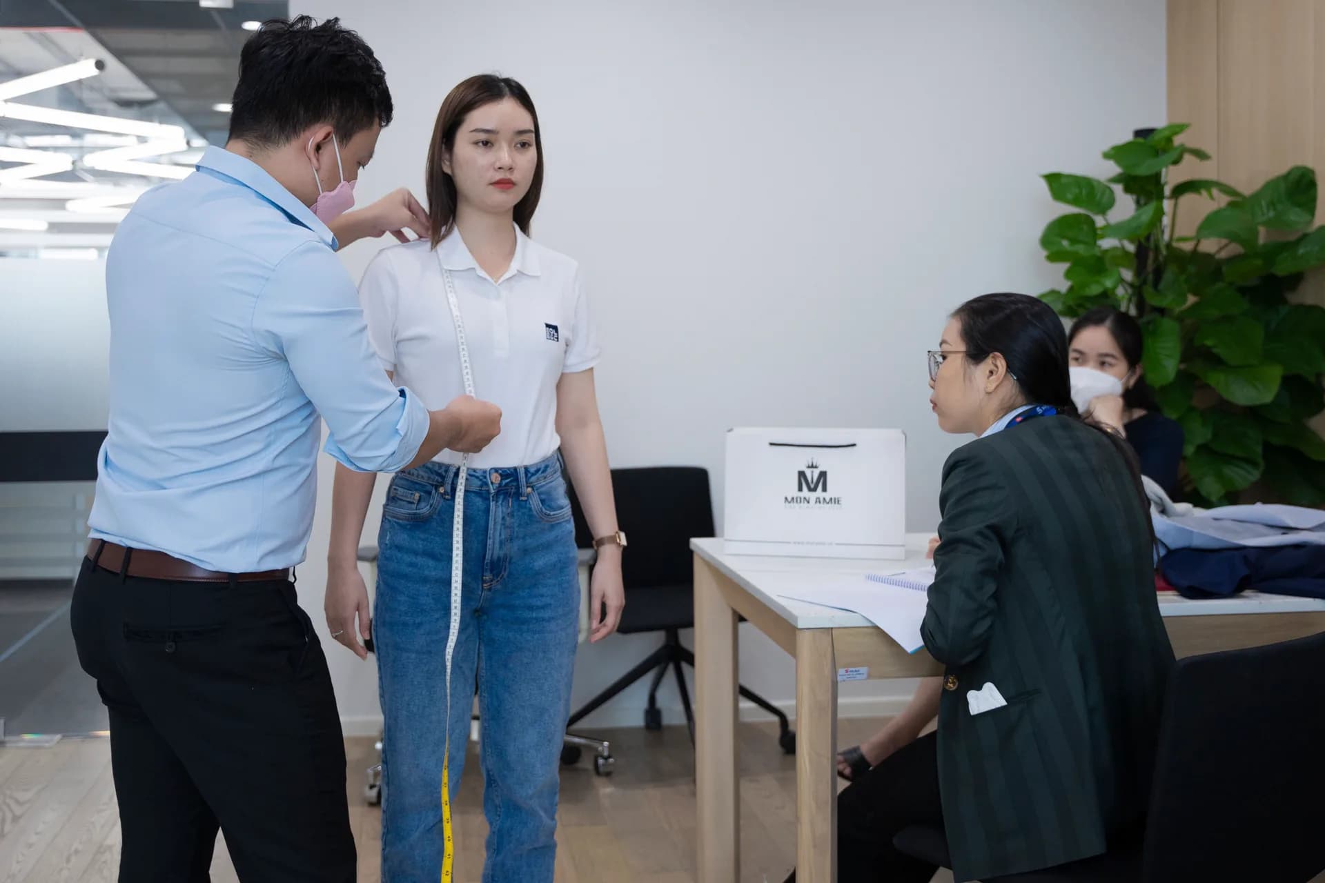 Đo vai và chiều dài thân áo cho nhân viên nữ mặc polo công ty