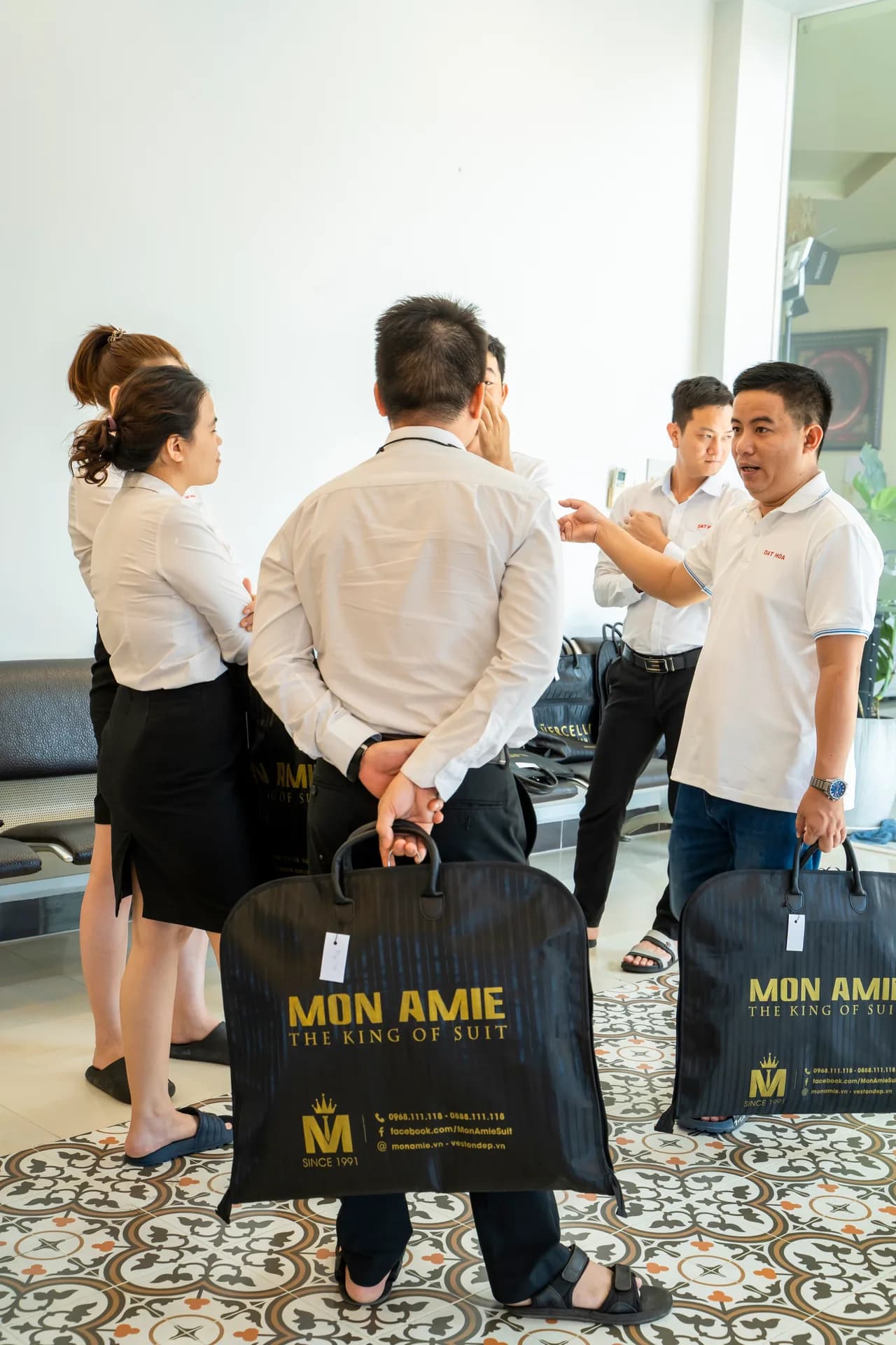 Nhân viên cầm túi đựng đồng phục Mon Amie trong ngày nhận đồ tại công ty