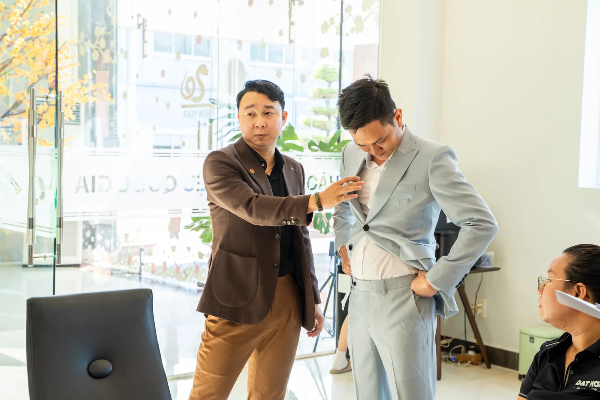 Chỉnh form vest xám xanh cho nhân viên nam ngay tại sảnh công ty